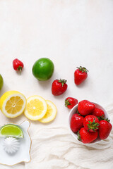 Juicer and ingredients for preparing strawberry lemonade on white background