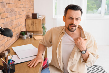 Young man having panic attack in office