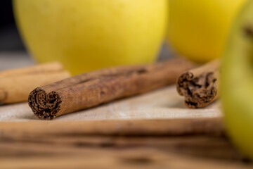 Sticks of real cinnamon on a board with apples