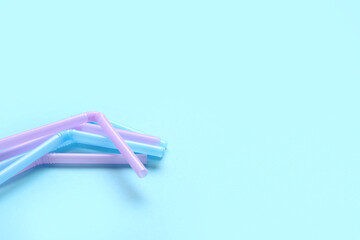 Different plastic straws on blue background