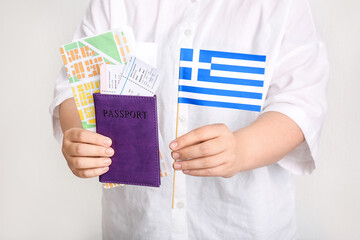 Woman holding passport, flag of Greece, map and tickets on white background. Tourism concept