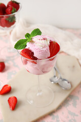 Glass of strawberry ice cream with mint on grunge table, closeup