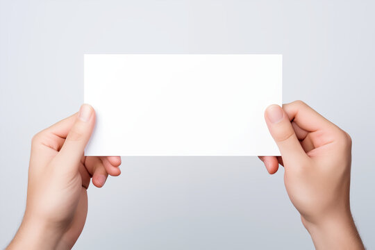 Female hand holding a blank business card over white background