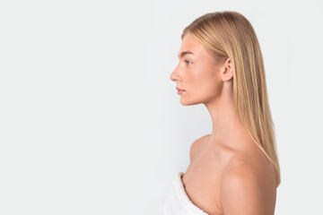 Profile shot of young blonde woman calmly posing looking aside