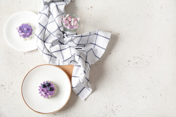 Plates of panna cotta with blueberry and beautiful gypsophila flowers on white table