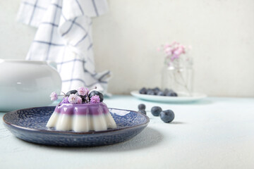 Plates of panna cotta with blueberry and beautiful gypsophila flowers on white table