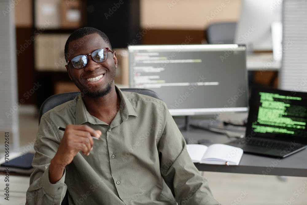 Aufkleber waist up shot of cheerful african american programmer wearing glasses looking at camera while sittin