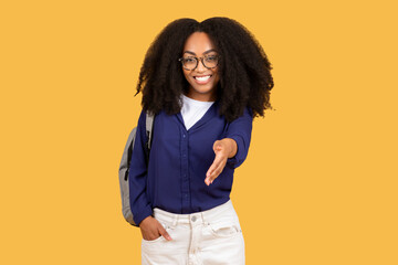 Friendly black lady student reaching out for handshake on yellow background