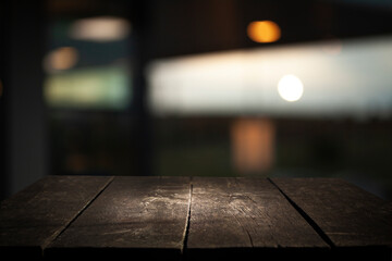 Empty dark wooden table in front of restaurant abstract blurred bokeh background. can be used to...
