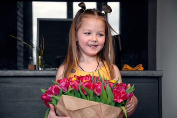 A little girl with a big bouquet of tulips. Beautiful bunch of flowers as a gift for Valentine's Day, Women's Day 8 March, birthday, holiday