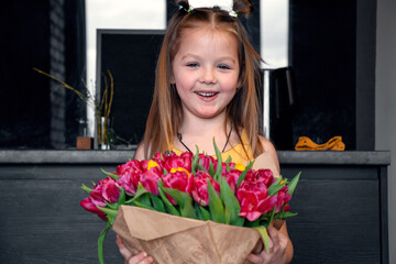 A little girl with a big bouquet of tulips. Beautiful bunch of flowers as a gift for Valentine's Day, Women's Day 8 March, birthday, holiday