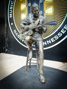 Nashville, Tennessee - USA: Statue of Chet Atkins outside Musicians Hall of Fame, sitting on stool under museum logo