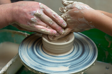 Clay, ceramics or hands in a design workshop working on an artistic cup or mug. The hand of a creative artist or worker making crafts in sculpture