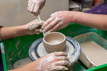 Clay, pottery or hands in designer workshop working on an artistic cup or mug mold in small business studio. Hand of creative artist or worker manufacturing handicraft products in sculpture