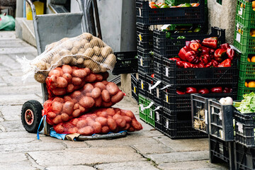 A handcart loaded with sacks of potatoes and several stacked boxes full of organic vegetables...