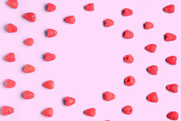 Frame made of fresh raspberries on pink background