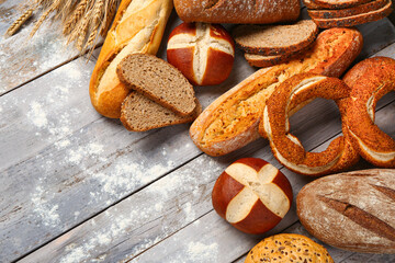 Different types of bread on grey wooden table