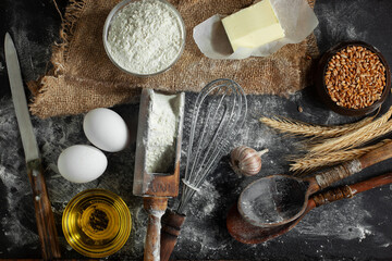 The process of kneading dough in the kitchen. Eggs, flour and other ingredients on the kitchen table in a composition.