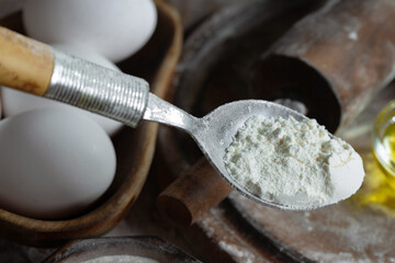 Kneading dough with flour and eggs, on an old background