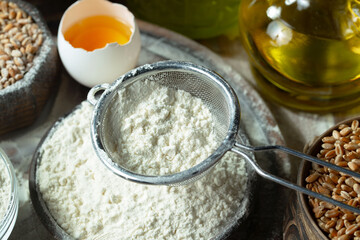 The process of kneading dough in the kitchen. Eggs, flour and other ingredients on the kitchen table in a composition.