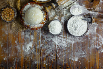 Kneading dough with flour and eggs, on an old background