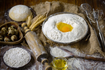 Kneading dough with flour and eggs, on an old background