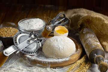 The process of kneading dough in the kitchen. Eggs, flour and other ingredients on the kitchen table in a composition.