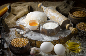 Kneading dough with flour and eggs, on an old background