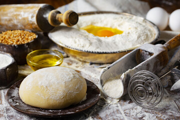 The process of kneading dough in the kitchen. Eggs, flour and other ingredients on the kitchen table in a composition.