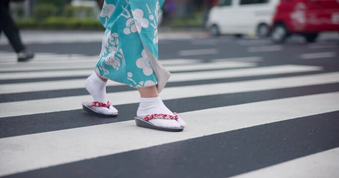 Japanese woman, feet and walking in kimono, city and pedestrian crossing for heritage celebration in streets. Person, setta sandals and traditional clothes in tokyo culture and wellness in fashion