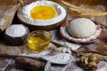 Kneading dough with flour and eggs, on an old background