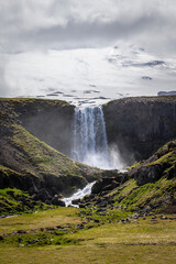 Wounderful Svoedufoss waterfall in front of the massive Snaefellsjoekull glacier in Iceland