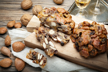 Pangiallo and vin santo, traditional Italian dessert with honey, candied fruit, flour and dried fruit on wooden table.