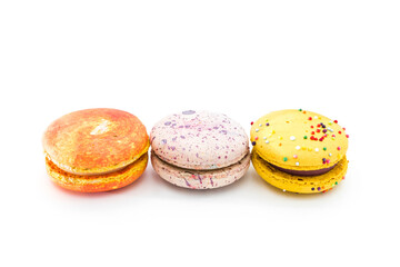 Sweet yummy macarons isolated on white background. Brightly stacked macaroons. Tasty colorful macaron. Three multi-colored orange, pink and yellow macaroons. French pastry made from egg whites.
