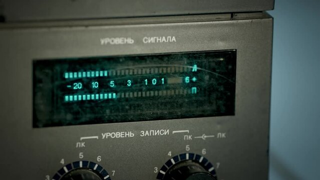 Signal level indicator of a vintage reel-to-reel recorder. Closeup of a playing reel-to-reel recorder. Slowmotion, footage 4K. 