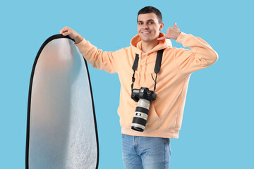 Male photographer with camera and lighting equipment showing 