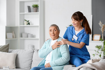 Senior woman with caregiver hugging at home