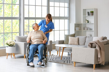 Senior woman in wheelchair with caregiver at home