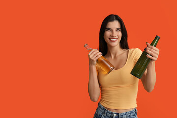 Beautiful young woman with bottles of cold beer on orange background