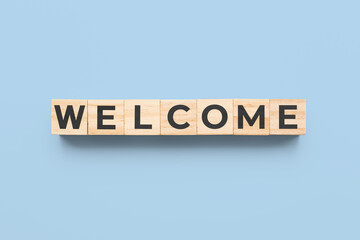 welcome wooden cubes on blue background