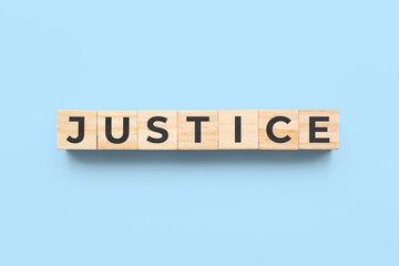 justice wooden cubes on blue background