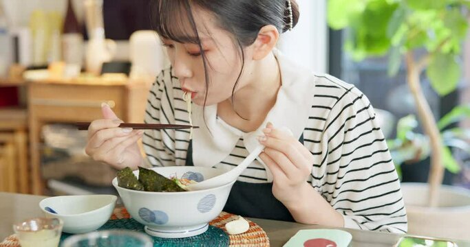 Japanese woman in restaurant, eating ramen and food for lunch or dinner. Noodles, bowl and a young hungry person, customer or girl with chopsticks to enjoy healthy meal or traditional cuisine alone