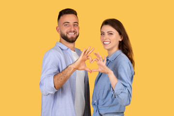 Happy couple forming heart shape with hands, affectionate pose