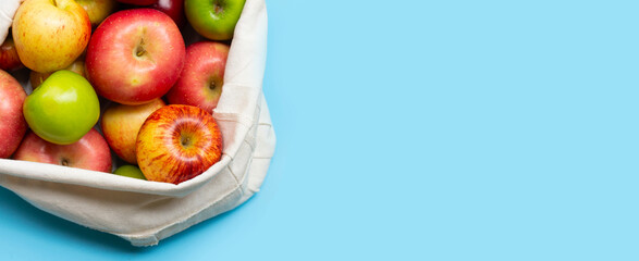 Variety of fresh apples on blue background.