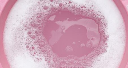 White detergent foam bubble, pink background.