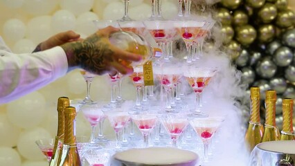 Bartender pours champagne glasses. Champagne glasses standing in a tower at the wedding party. Champagne glass pyramid - Powered by Adobe