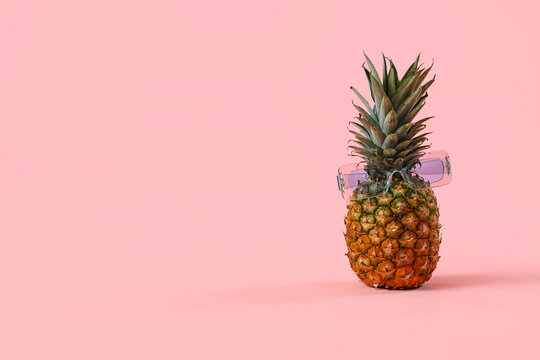 Cool pineapple with sunglasses on pink background