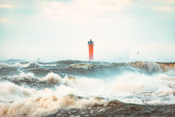 Lighthouse on the sea during Stormy weather in Riga, Latvia. Huge waves crashing down the coast