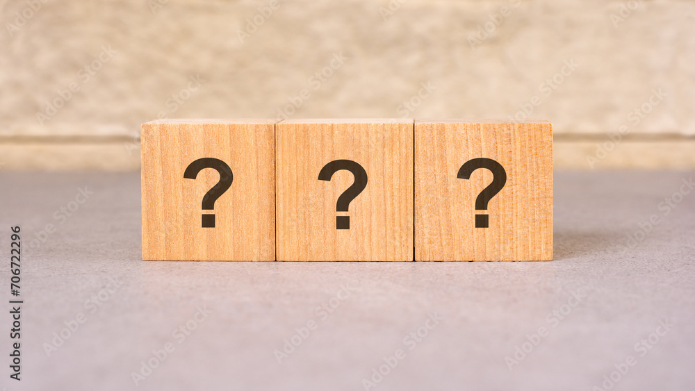 Poster three wooden blocks with question marks over a grey background