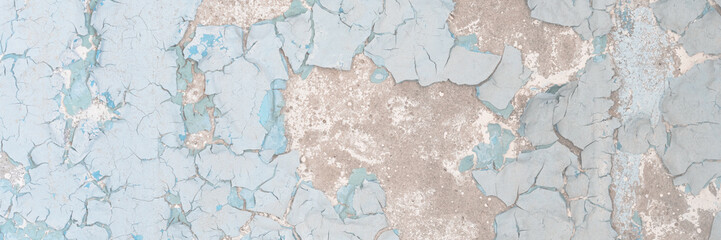 Blue peeling paint on the wall. Old concrete wall with cracked flaking paint. Weathered rough...